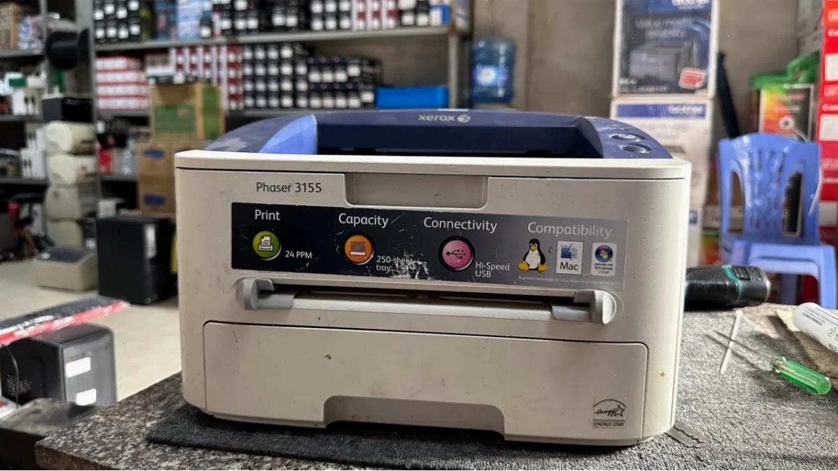 Kỹ thuật viên đang kiểm tra máy in Xerox 3155